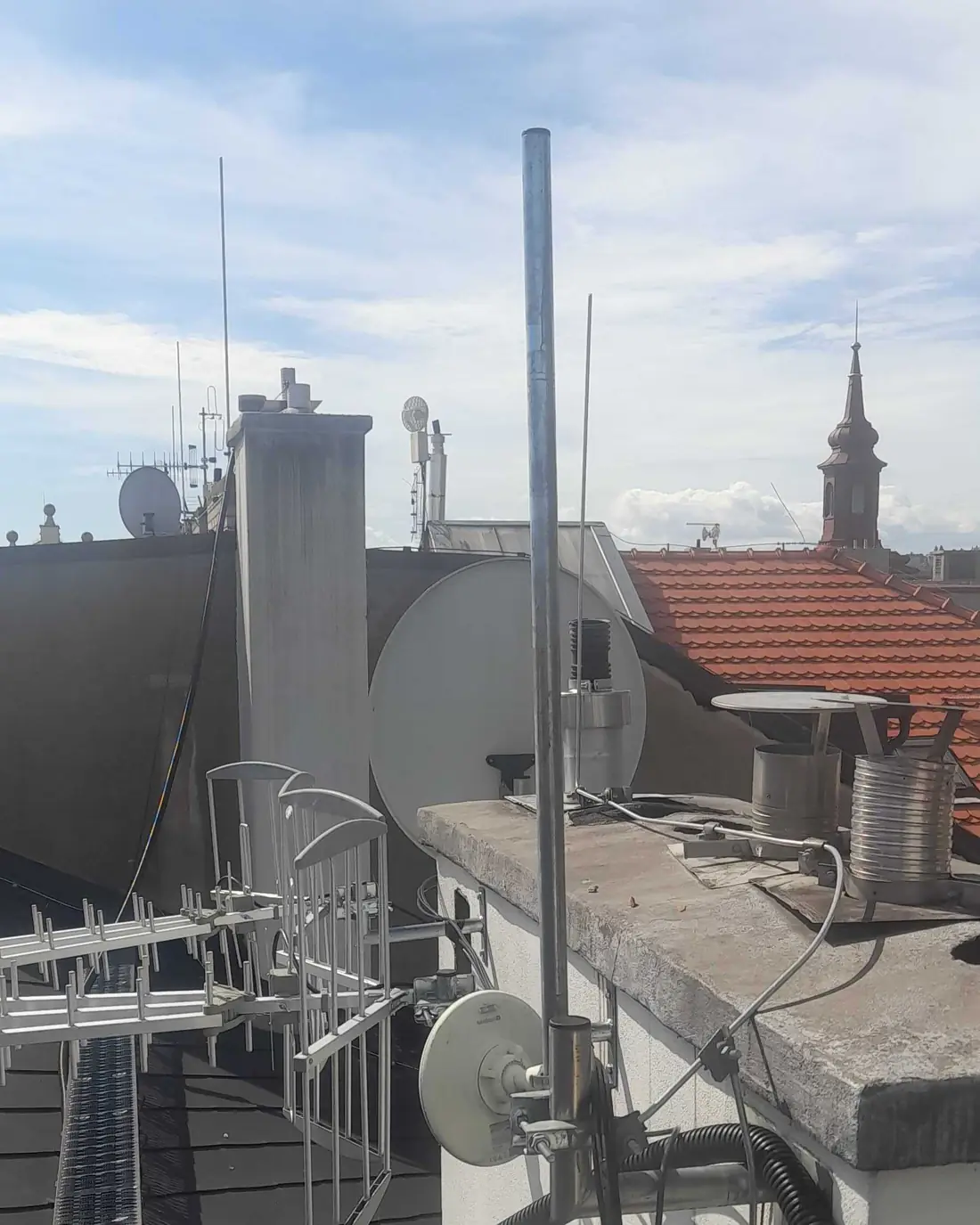 Naše anténa a kabeláž na střeše bytového domu v centru Prahy
